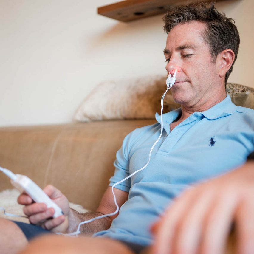 Man using the rhinitis sinusitis allergy treatment device while relaxing