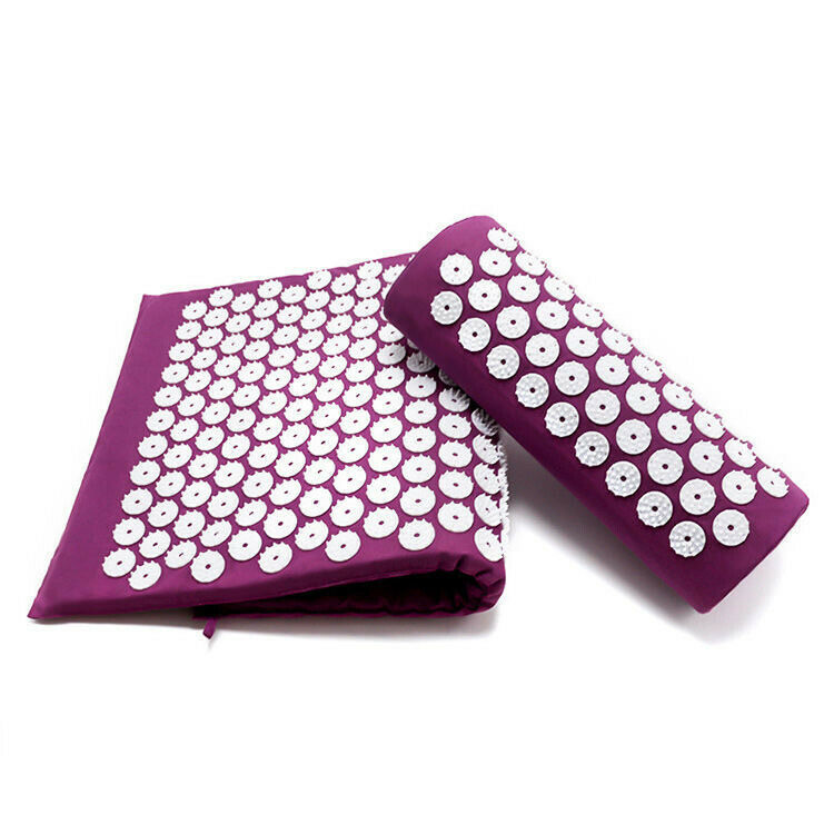 Purple acupressure yoga mat folded alongside a rolled acupressure pillow