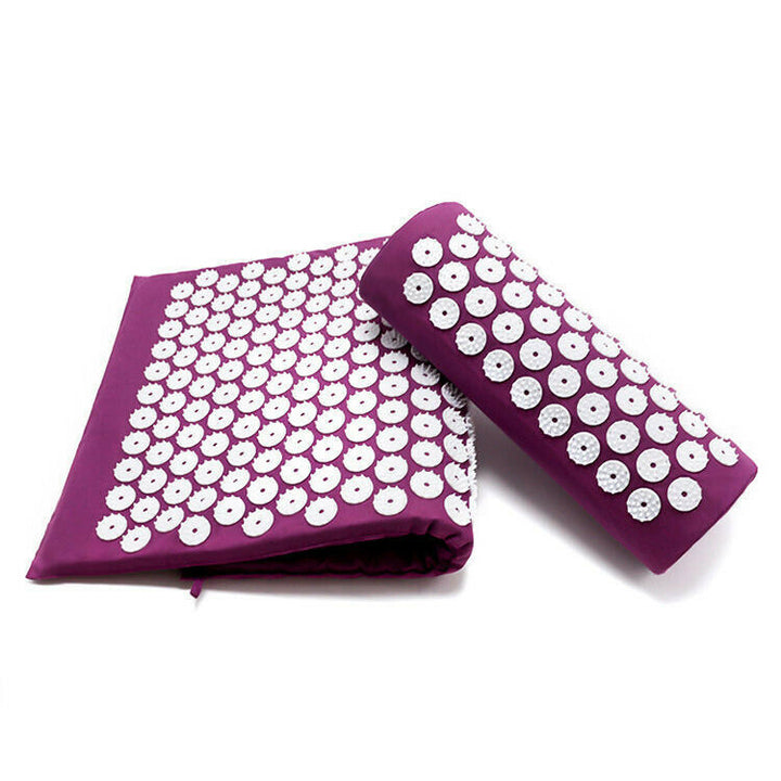 Purple acupressure yoga mat folded alongside a rolled acupressure pillow