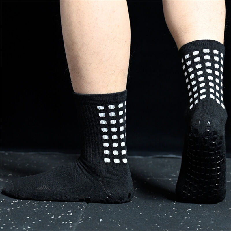 Person wearing black athletic non-slip grip socks showing sole traction dots