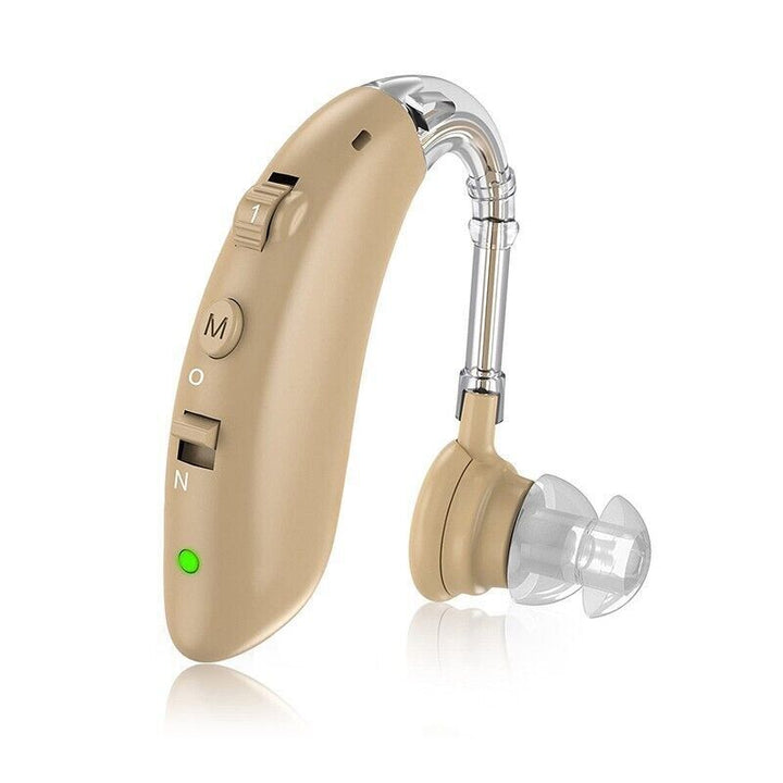 Behind the ear sound amplifier resting on a clean white surface with ear tips