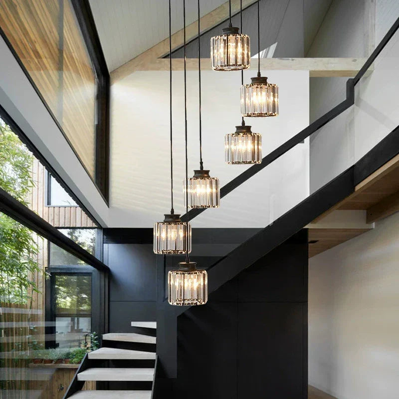 Modern long glass chandelier suspended in a multi-level staircase entryway