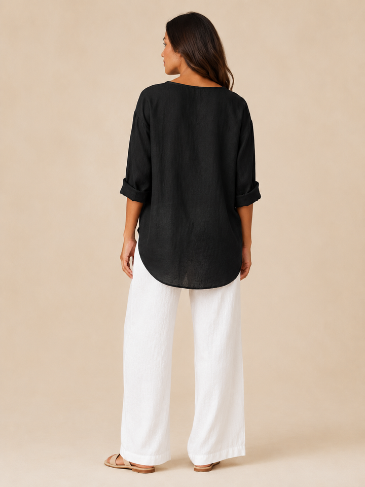 Back view of a woman showcasing the curved hemline of the black blouse