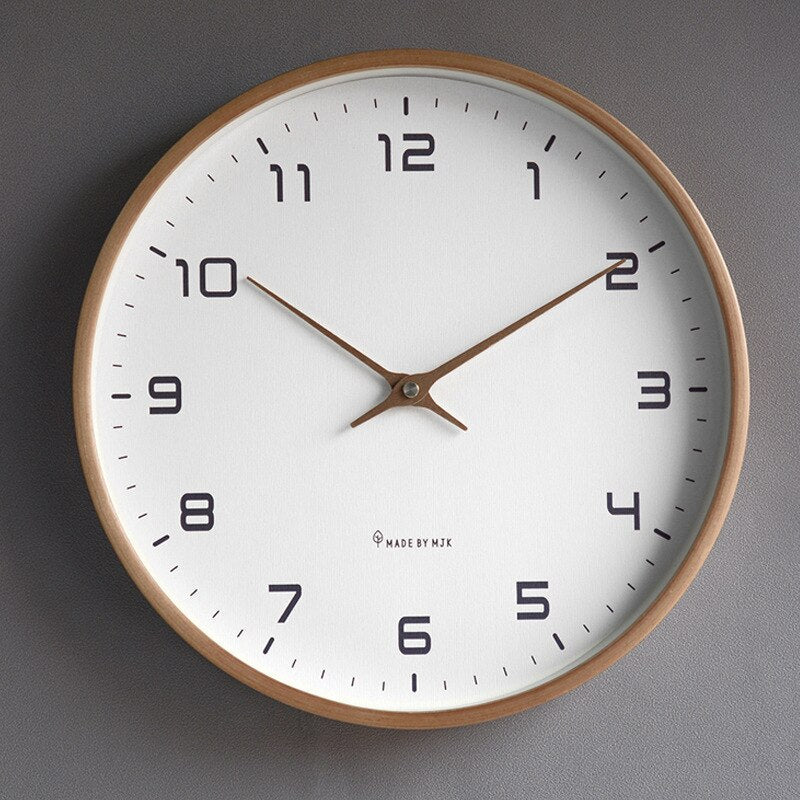 Close-up shot of the Scandinavian wooden wall clock featuring bold numbers and clear hands against a white face.