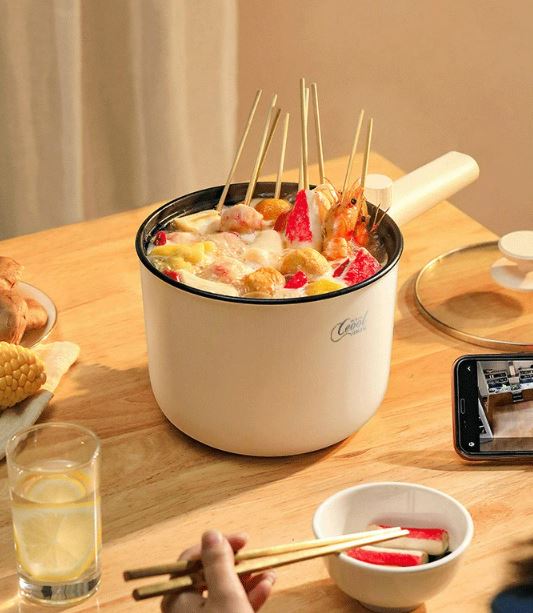 Electric cooking appliance lid removed to show steam rising from food