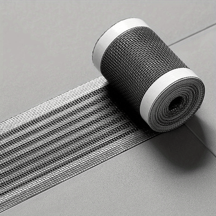 Roll of black self-adhesive mesh drain cover displayed on a tiled floor