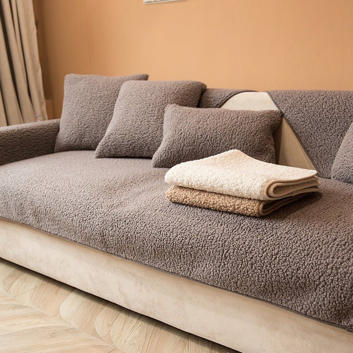 Brown plush sofa cover folded neatly on top of a matching sofa setup