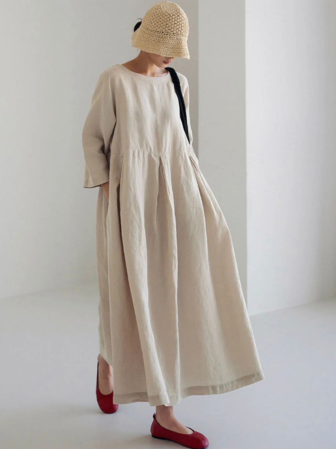 Woman wearing beige oversized maxi dress with hat