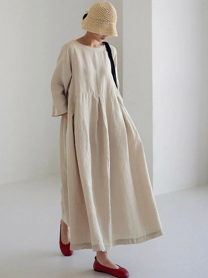 Woman wearing beige oversized maxi dress with hat