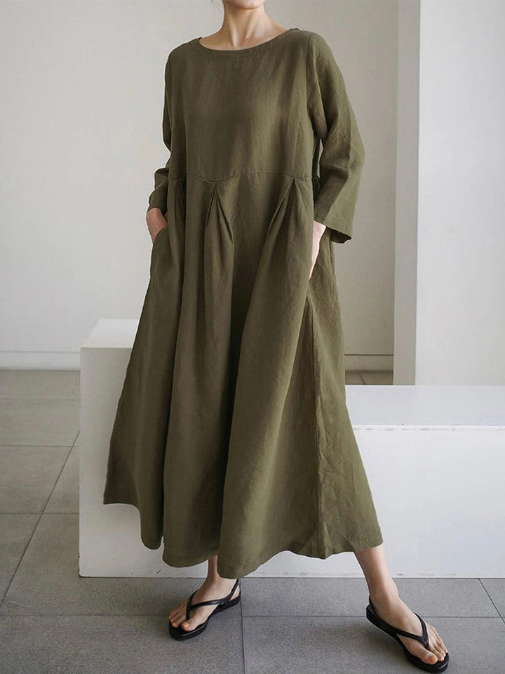 Woman posing in olive green maxi dress with pockets