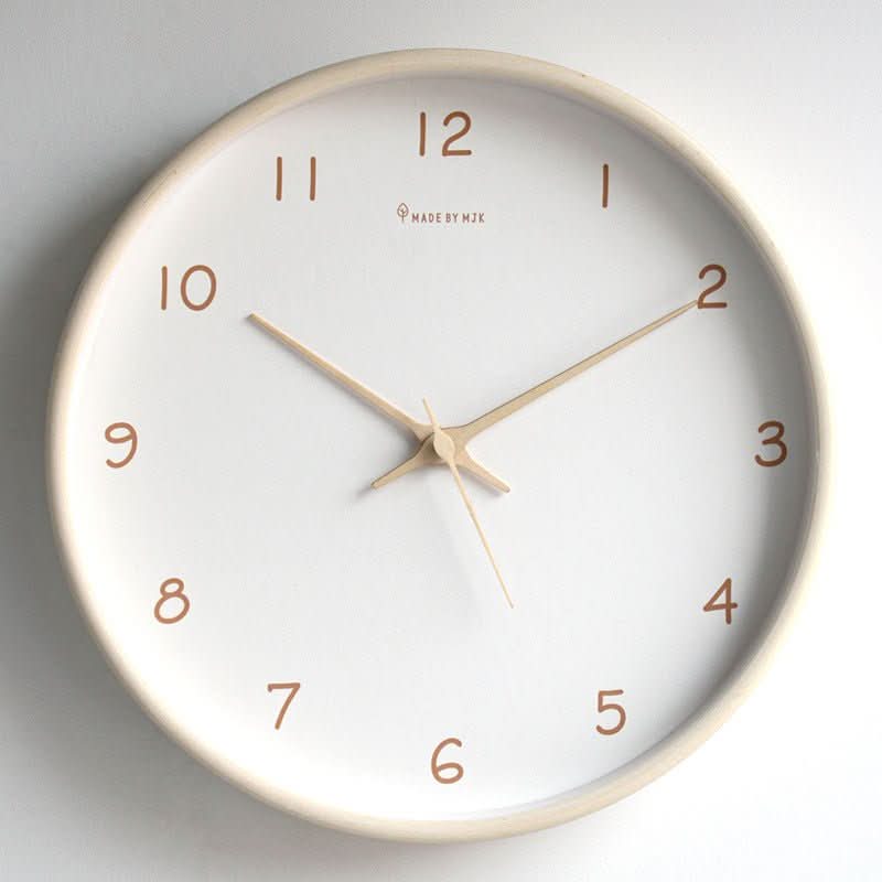 Cream solid wood silent analog wall clock hanging on a light wall