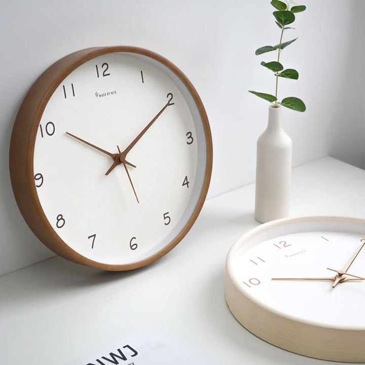 Cream and brown wooden wall clocks displayed together with home decor
