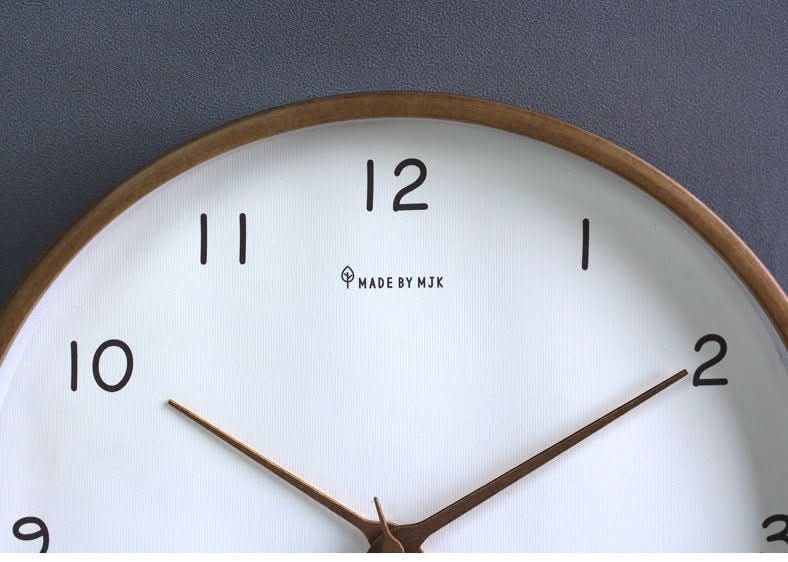 Close-up of wooden wall clock hands and minimalist dial