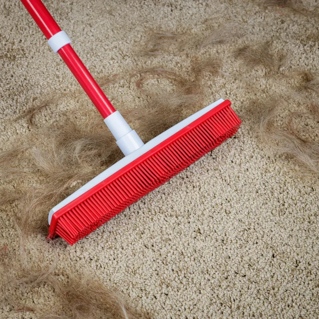 Silicone telescopic broom head pulling pet hair from a beige carpet