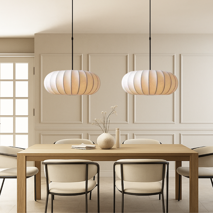 Two silk pendant lamps hanging above a wooden dining table in a stylish interior