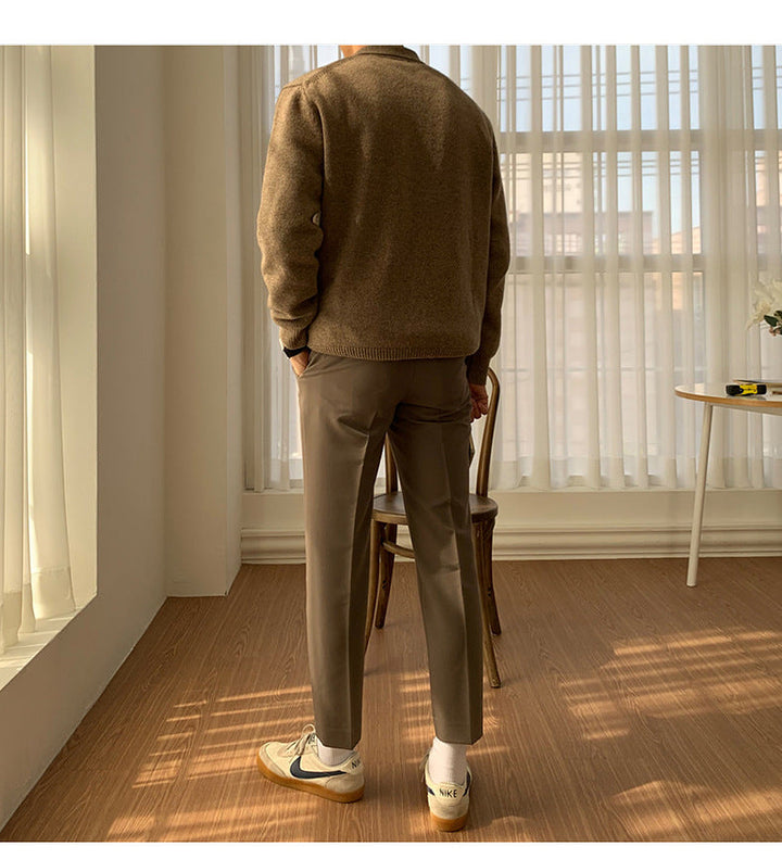 Back view of a man wearing a brown button polo sweater and trousers