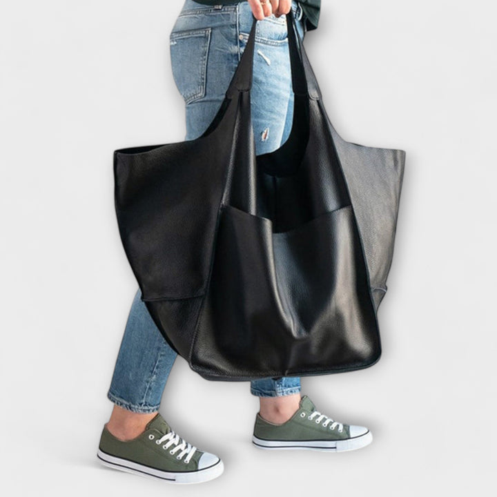 Large handbag worn by a model to demonstrate scale and shoulder fit.