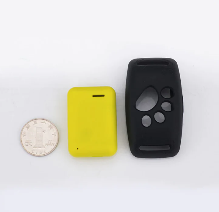 Yellow GPS tracker device next to a coin for scale and black collar case