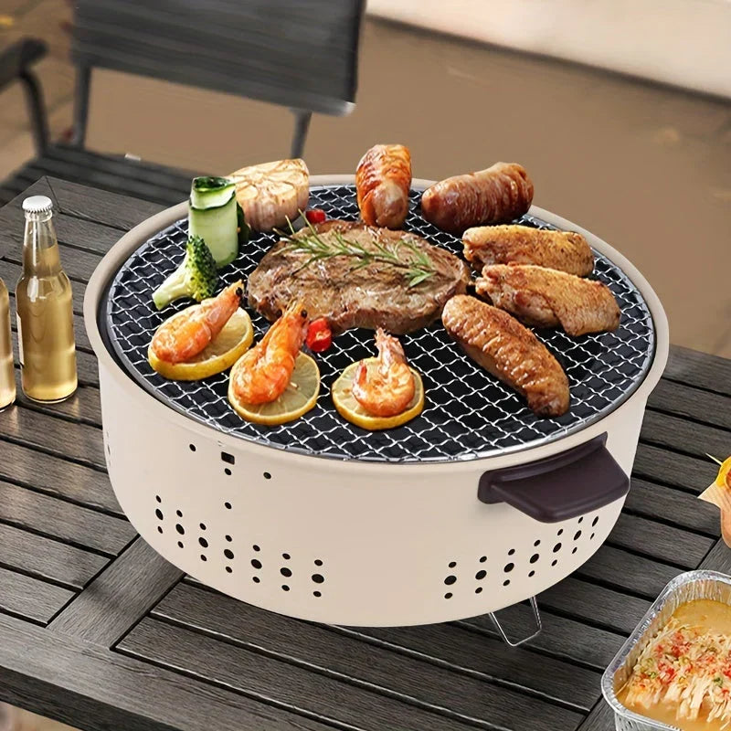 Portable smoke-free charcoal grill loaded with grilled meat and vegetables on a table