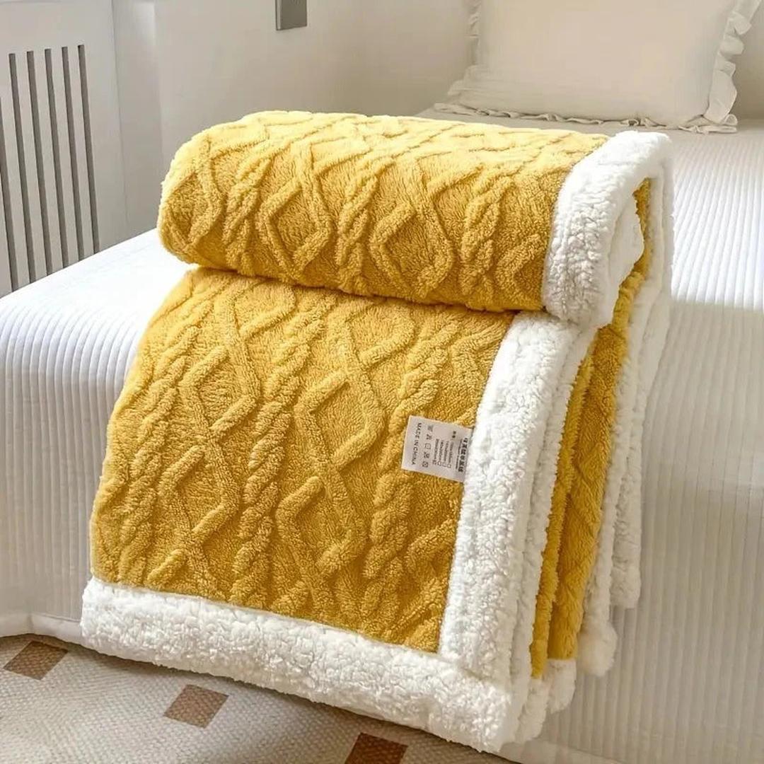 Lightweight cozy throw blanket spread out on a plush bed