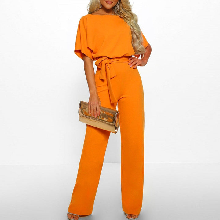 Model wearing a vibrant yellow wide-leg jumpsuit with a self-tie belt and matching clutch