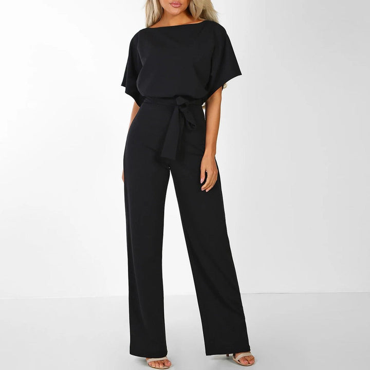 Model wearing a classic black wide-leg evening jumpsuit with a bateau neckline
