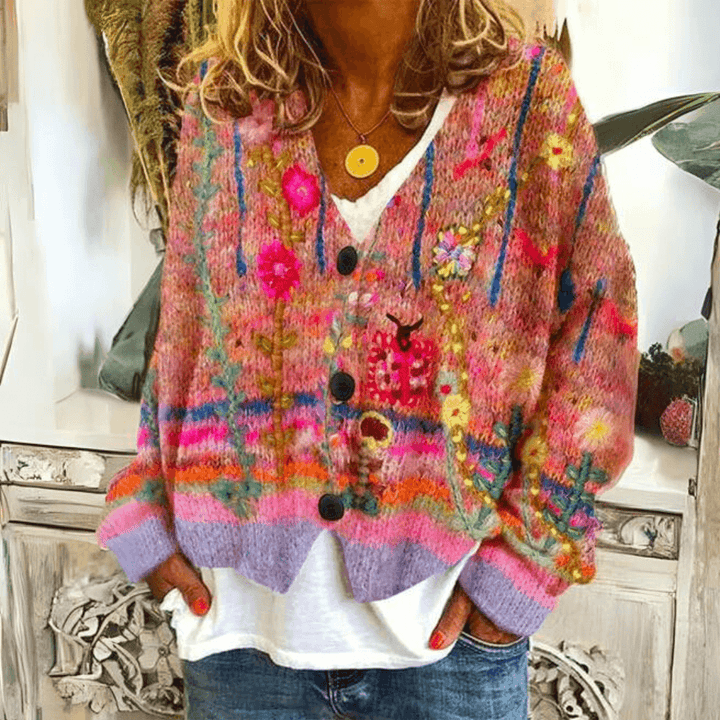 Woman posing in red floral embroidered knit cardigan paired with jeans