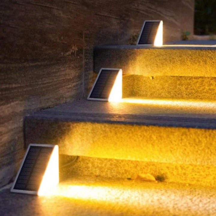 Detailed shot of a solar step light fixture glowing on an outdoor staircase