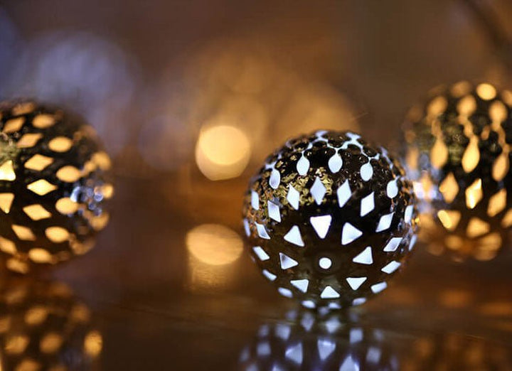 Solar Moroccan LED garden lights glowing on outdoor patio string