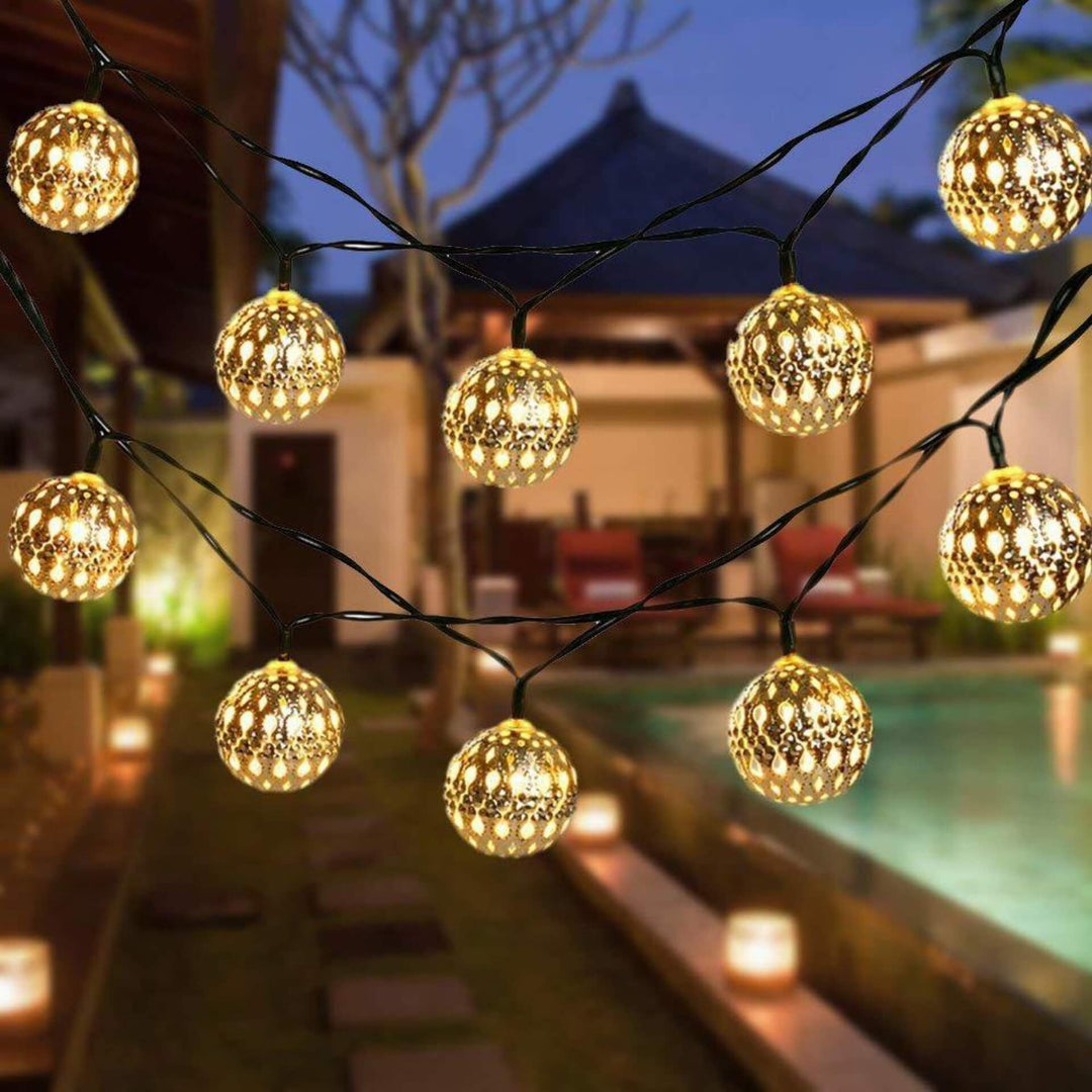 Moroccan style metal LED garden lights glowing outdoors at night