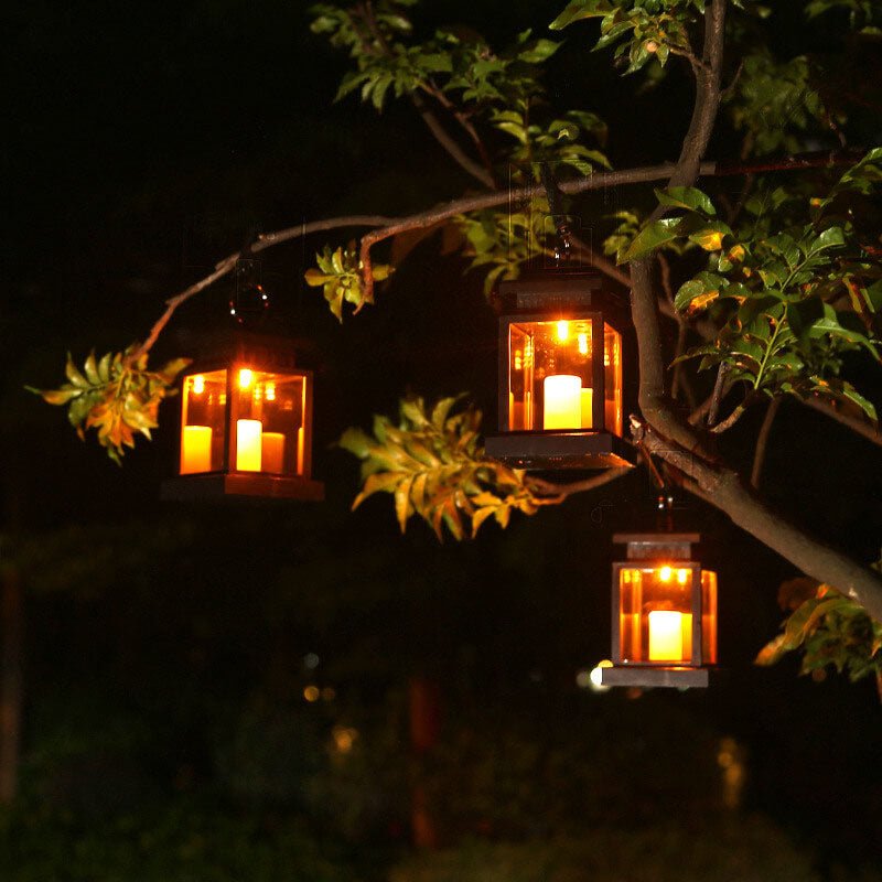 Solar hanging lanterns glowing at night hanging from tree branches
