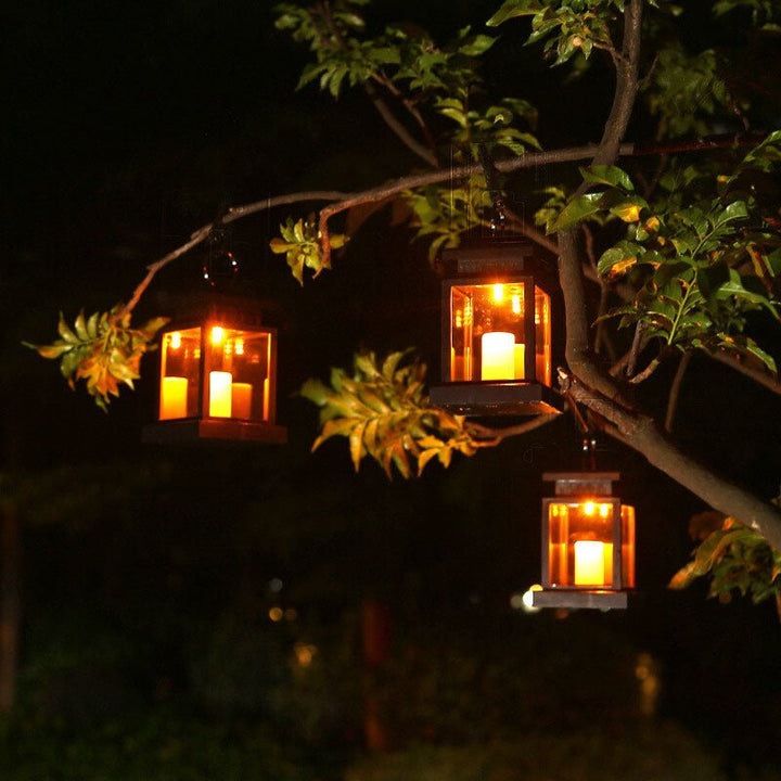 Solar hanging lanterns glowing at night hanging from tree branches