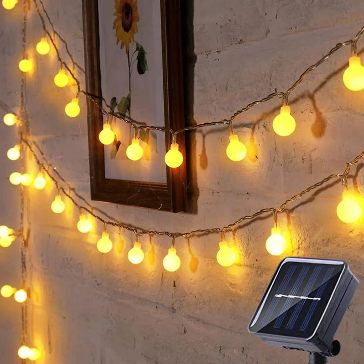 Eco-friendly energy saving outdoor string lights draped along a fence