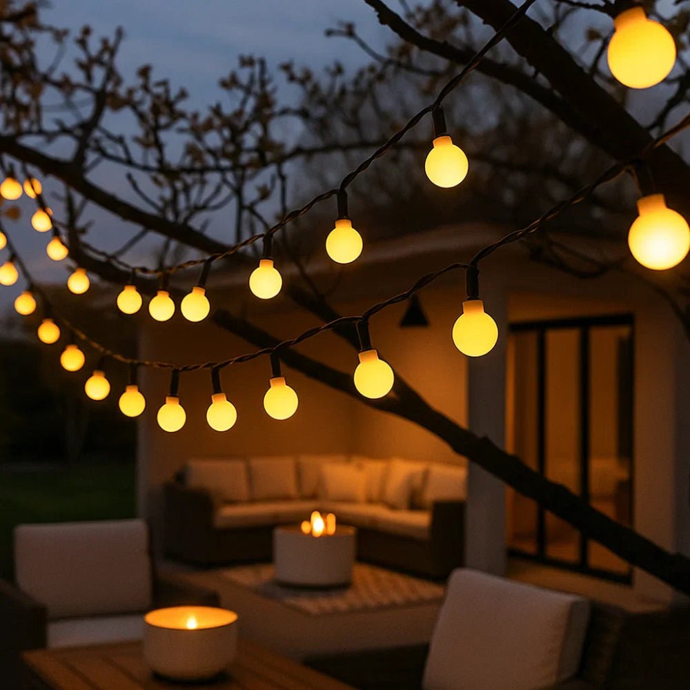Solar LED string lights glowing warmly on outdoor patio trees at dusk