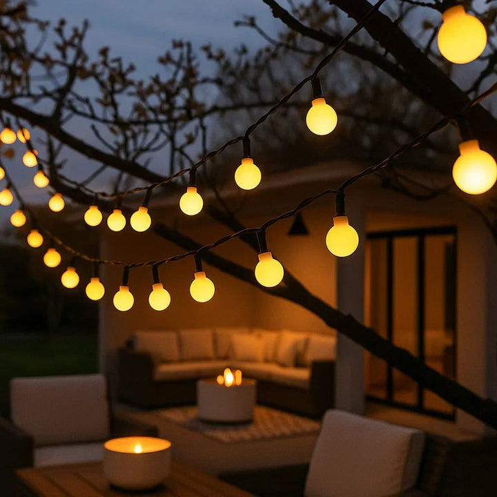Solar LED string lights glowing warmly on outdoor patio trees at dusk