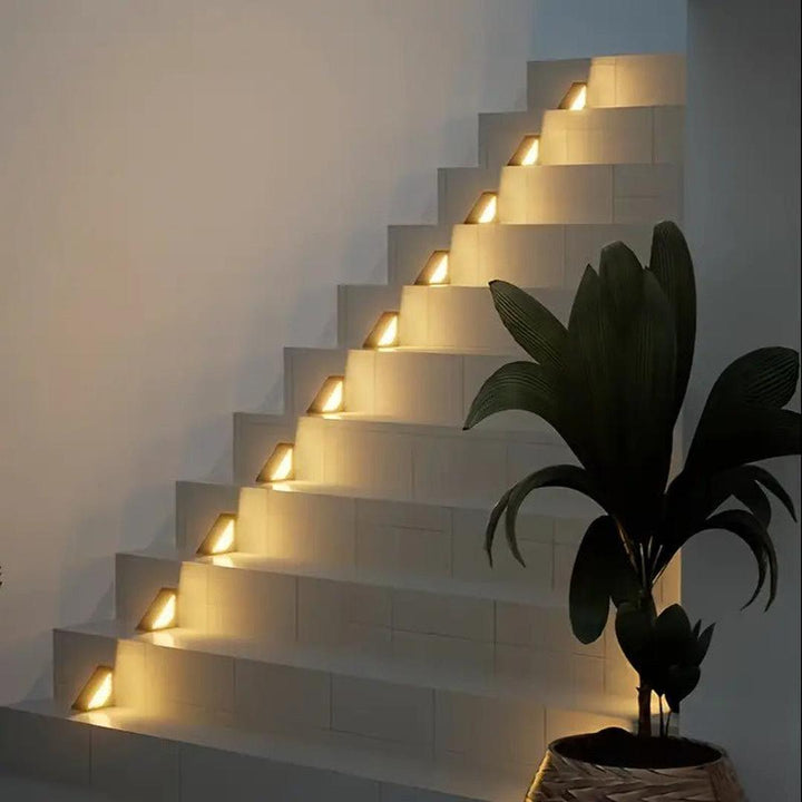 Triangular solar path light glowing softly along an exterior garden walkway