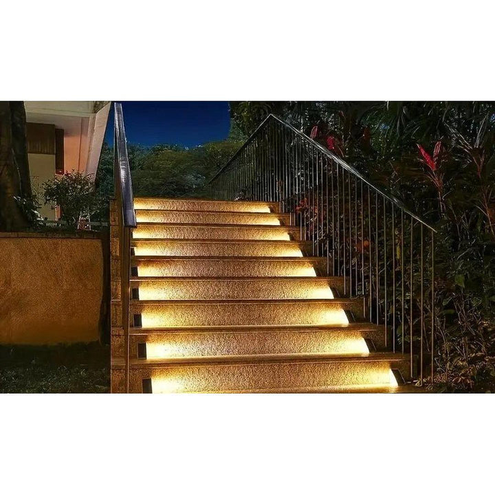 Close-up of LED solar outdoor stair light mounted on a wooden deck step