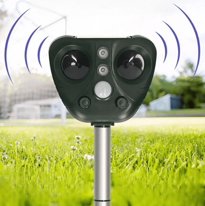 Solar powered ultrasonic bird repeller mounted on a lawn against a bright outdoor background