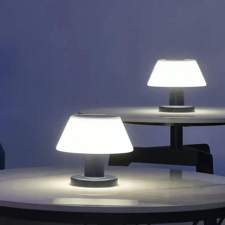 Wireless solar LED table lamp illuminated against a dark background