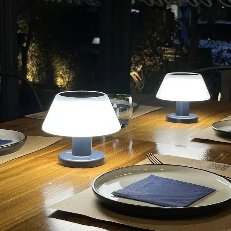 Modern solar table lamps glowing on a wooden dining table at night