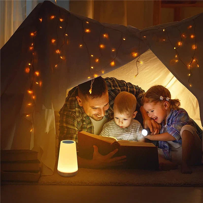 USB rechargeable bedside night light glowing with warm ambient light on a nightstand