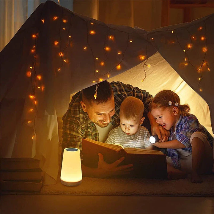USB rechargeable bedside night light glowing with warm ambient light on a nightstand