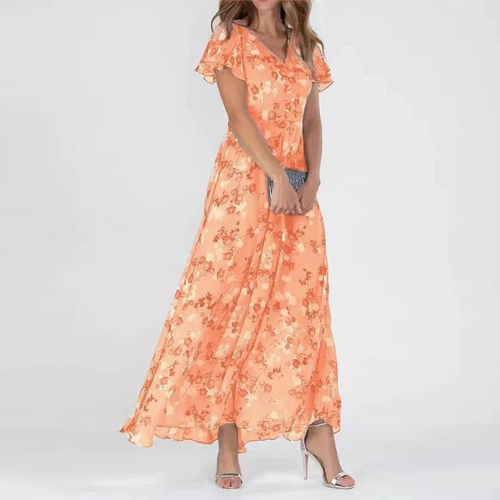 Woman wearing an orange floral wrap maxi dress with flutter sleeves