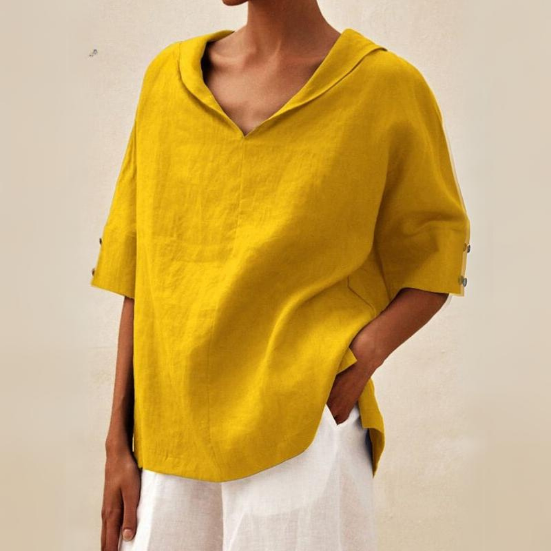 Woman wearing a yellow relaxed fit V-neck top paired with white trousers