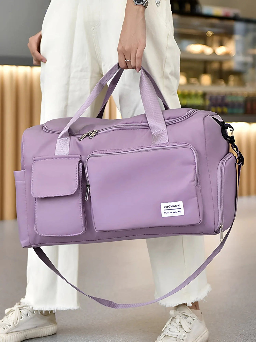 Person holding a purple travel duffel bag