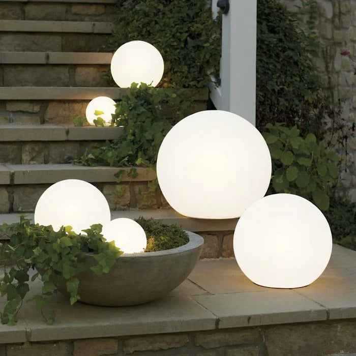 Illuminated spherical garden lights arranged on stone steps at night