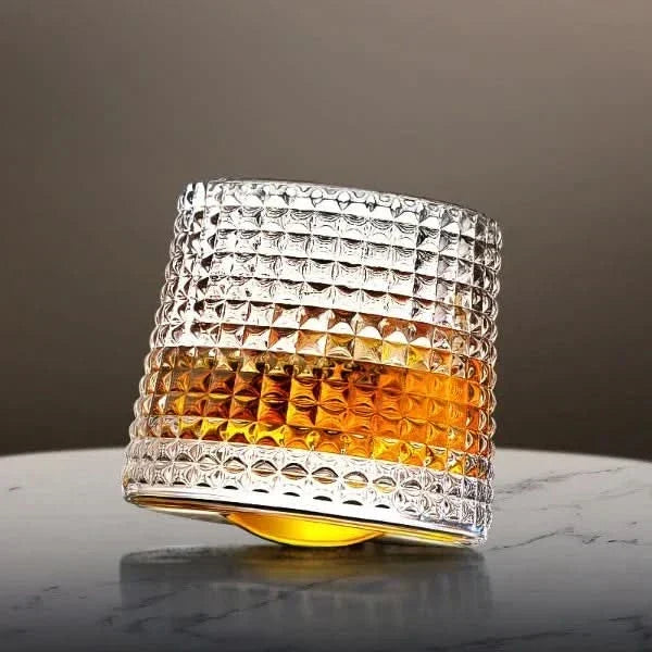 Spinning Japanese Edo whiskey glass in Royal Checkers style filled with amber spirit on a marble table.