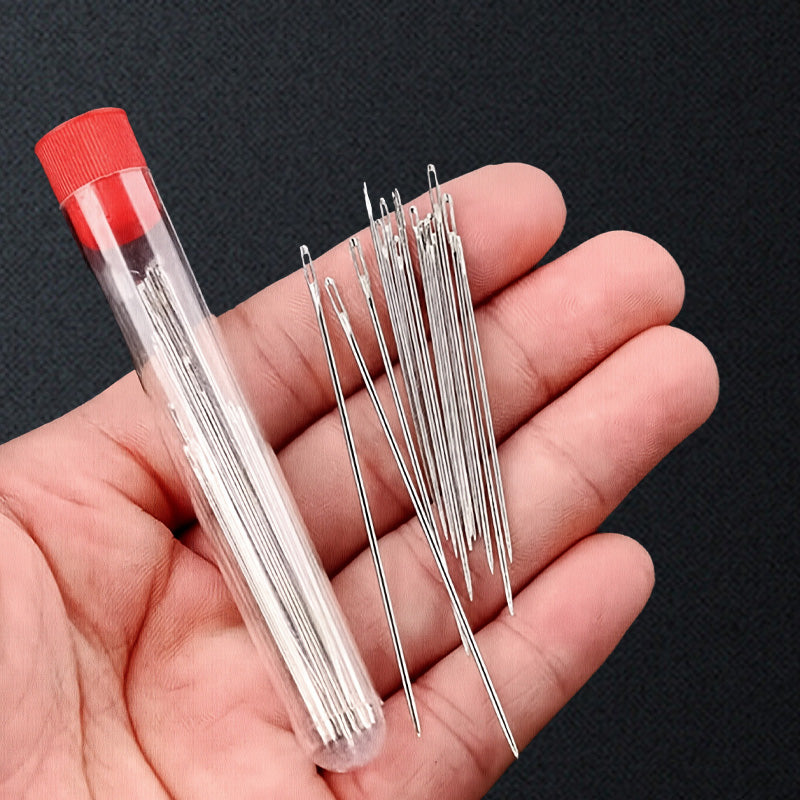 Portable sewing tool set open to display organized pins, thimble, and needle threader