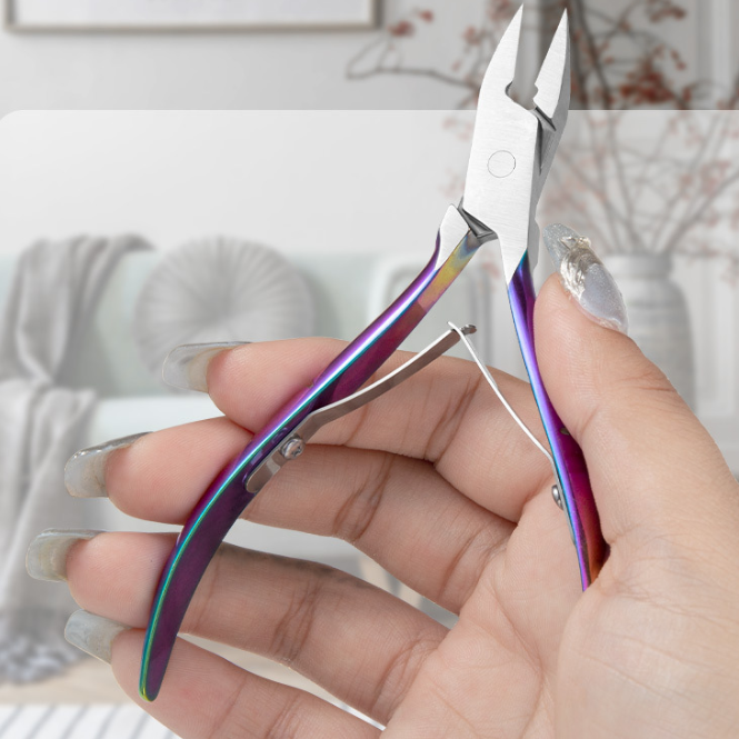 Hand holding rainbow-finished angled nail clippers showcasing ergonomic grip