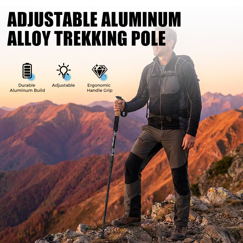 Hiker standing on a mountain ridge holding an adjustable aluminum trekking pole at sunset